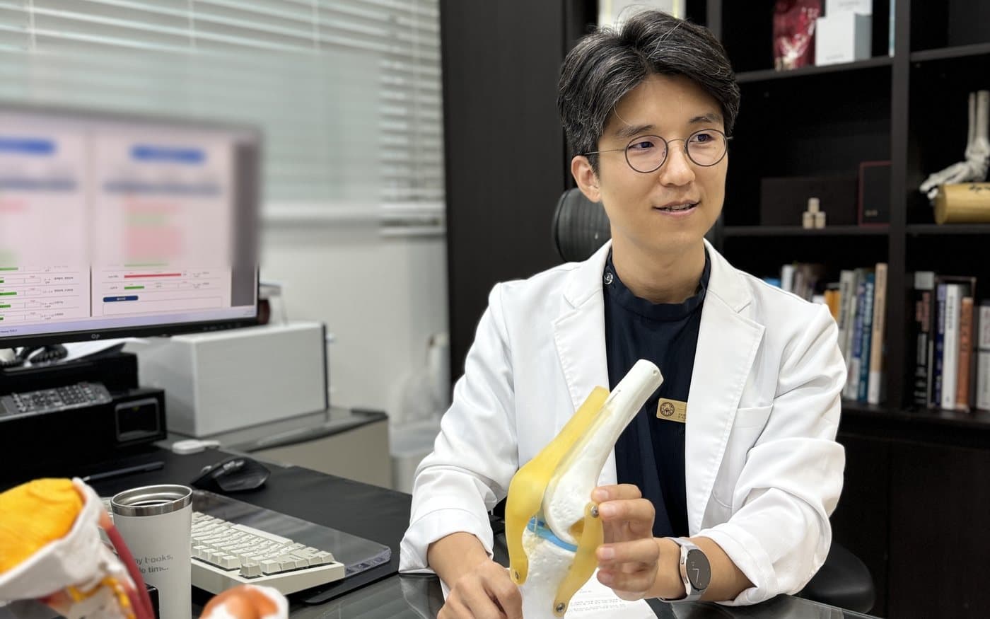 무릎 관절 모형으로 통증의 원인을 설명하는 장윤호 대표원장
