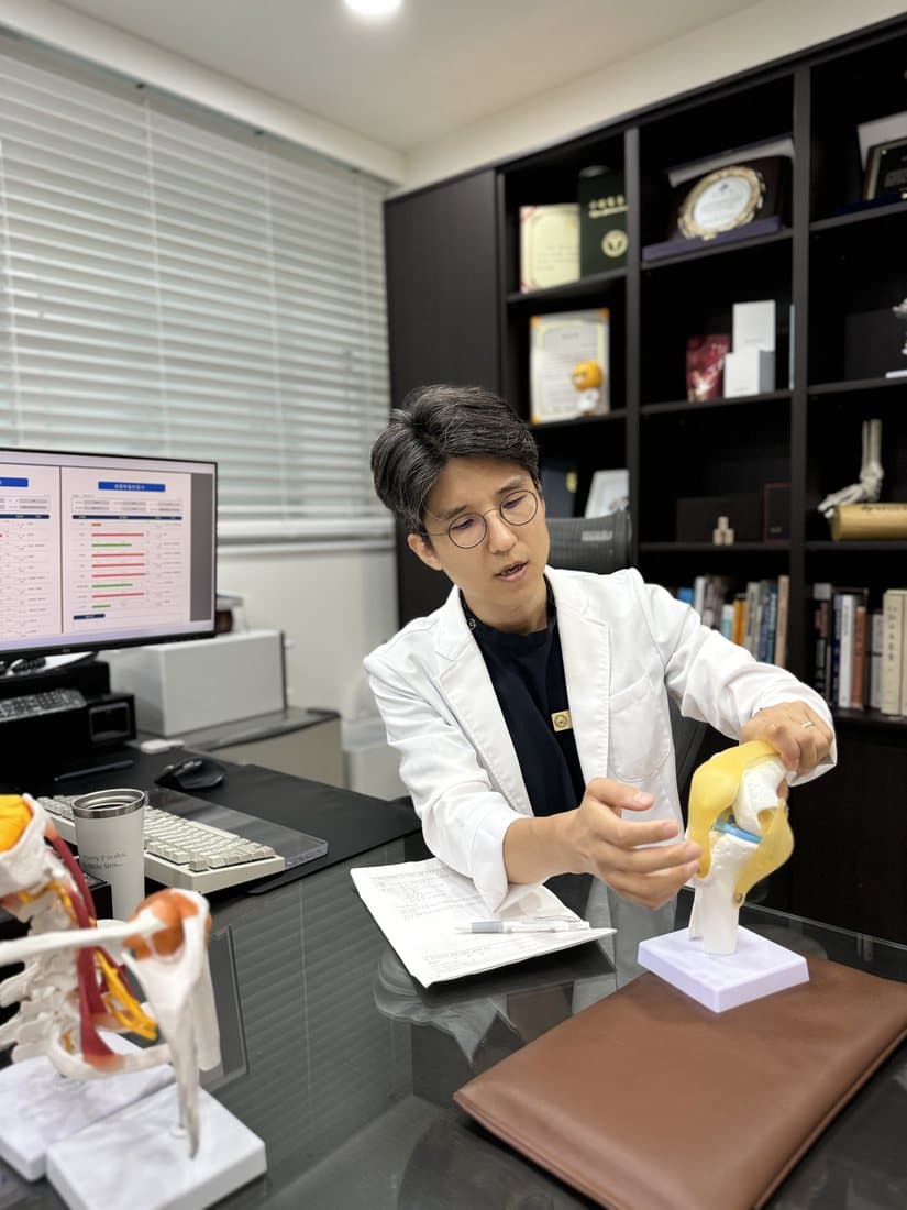 무릎 모형으로 환자에게 설명하는 장윤호 대표원장